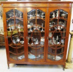 Bela estante para livros em rádica com prateleiras internas em madeira e 3 portas de vidro. Detalhes em bronze. Possivelmente de fabricação da renomada casa LEANDRO MARTINS. Brasil, início do séc. XX. Medidas: 165 cm x 43 cm; Altura: 180 cm.