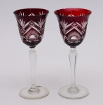 Par de taças em cristal da Bohemia na cor vermelha. Apresentam pequenos bicados nas bordas. Medida: 21,5 cm.