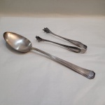 Lote contendo 2 peças em metal prateado, sendo: A) colher de arroz em metal inglês Mappin & Webb (27 cm); B) Pegador de gelo em metal prateado Fracalanza (16 cm).