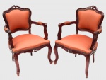 Par de cadeiras de braços, poltronas, estilo Luis XV em madeira nobre e estofadas em tecido na tonalidade cereja. Largura: 65 cm. Altura do encosto: 93 cm.