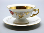 PORCELANA - Xícara de café em porcelana comemorativa Brasil e EUA e pintura em ouro. Med. 4,5 cm e 10 cm.