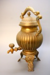 METAL - Antigo samovar em metal dourado no estilo inglês ornado por firmados em relevos e pés lavrados. Alt. 40 cm.