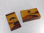 Duas peças em madeira marchetada com paisagem, sendo caixa retangular e porta-bloco. Apresentam sinais de uso. med. respectivas 4 x 16 x 10cm e 2 x 16 x 9cm.