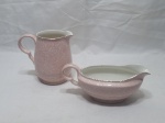 Lote de leiteira e molheira em porcelana inglesa rosa com friso prata. Medindo a leiteira 13cm de altura. Com pequenos bicados.