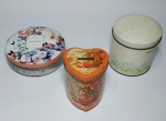 Lote de 3 lindas latas vazias, representando: Perfume e sabonetes, sendo que uma cofre no formato de coração. Medida da maior: 10 cm de altura x 10 cm de diâmetro.. Medida da menor: 13 cm de diâmetro x 5 cm de altura.