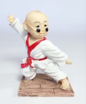 Linda escultura em resina representando jovem monge Shaolin - lutador de Kung Fu - Medida: 10 cm de altura x 9 cm x 5,5 cm. Obs: Possui pequeno bicado na borda do Kimono, conforme fotos.