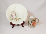 Lote 2 peças sendo 1 prato decorativo em porcelana real e 1 caneca porcelana schmidt decorado flores pintado a mão mede prato 24,5 cm e caneca 12,5 cm x 8 cm