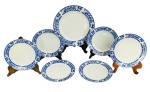 CHINA - Jogo de sobremesa em porcelana chinesa esmaltada contendo um prato maior para bolo e seis menores com registro da manufatura e bordas em floral azul. Medida do maior 27cm diâmetro.