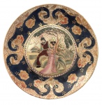 Prato de parede e ou coleção em porcelana oriental adornada com cena galante policromada e vibrante ouro. Possui registro. Mede 21cm diâmetro.