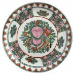 Prato para coleção em porcelana oriental fartamente adornado com flores em policromia. Possui registro no verso. Mede 18,5cm diâmetro.