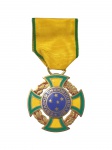 MILITARIA, Medalha de Guerra confeccionada em bronze esmaltado, instituída em 17 de agosto de 1944, anverso: cruz do templo com dístico central representando cruzeiro do sul, sobreposta a uma coroa de louro e carvalho; reverso a inscrição: Medalha de Guerra 22-VIII-1942 (data que o Brasil declarou guerra), fita em seda chamalotada nas cores verde e amarelo, medindo 4x4cm.