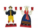 Par de candelabros para 2 velas confeccionados em madeire esmaltada representando Colonos em trajes típicos holandeses em policromia. Assinados na base. Medidas 29 x 15 x 8 cm