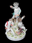 LUDWIGSBURG (Alemanha - 1758), Grande grupo escultórico confeccionado em porcelana alemã esmaltada na tonalidade branca representado trio de Puttinos, esmaltado em rica policromia, decorado por flores e folhagens em relevo, base com volutas em douração, apresentando ínfimos bicados, imperceptíveis restauros, peça de coleção, marcada, vide foto, medindo 40x23,5cm.