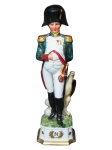 ESCULTURAS, Escultura confeccionada em porcelana esmaltada na tonalidade branca representando Napoleão Bonaparte ladeado por águia, esmaltado em policromia, base oitavada com monograma de Napoleão em vasta douração, medindo 32cm de altura.