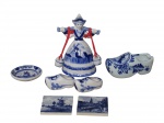 FAIANÇA HOLANDESA, Lote com 7 peças decorativas confeccionadas em faiança vitrificada com pintura holandesa na tonalidade azul, sendo: A) 3 sapatos, B) 2 azulejos decorativos, C) 1 pratinho decorativo e D) 1 sineta representando camponesa, maior medindo 12cm e menor 5cm.