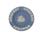 WEDGWOOD (Inglaterra), Cinzeiro confeccionado em biscuit na tonalidade azul, decorado por folhas de parreira e cachos de uva em relevo na borda e centro com figuras na tonalidade branca, medindo 11cm.