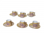 PORCELANA, Seis xícaras para café com seus respectivos pires confeccionados em porcelana esmaltada na tonalidade branca, decorado por flores na tonalidade lilás e realces em dourado, alça filetada a ouro, acondicionadas em estojo original com desgastes, medindo 5x6,5x5cm.