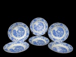 PORCELANA REAL BRASIL, seis (6) pratos rasos confeccionados em porcelana vitrificada branca nacional, centro aplicado com cena campestre adornada por faixas de flores e folhagens na tonalidade azul. Marcados no fundo. Um possui bicado na borda. Diâmetro 24 cm