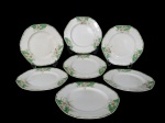 ALFRED MEAKIN ENGLAND, sete (7) pratos rasos confeccionados em faiança vitrificada inglesa da coleção Marigold - Princess Shape, estilo Art Deco, decorado com flores na tonalidade branca sobre fundo verde com detalhes em amarelo. Marcados no fundo. Um possui bicado no fundo. Diâmetro 23 cm.