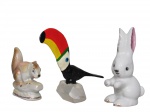 ESCULTURAS, Lote com 3 peças, sendo: A) 1 escultura representando coelho, confeccionada em porcelana esmaltada na tonalidade branca, vestígios de douração, medindo 12cm, B) 1 castor, confeccionado em porcelana nacarada esmaltada em policromia, medindo 7,5x7cm e C) 1 em resina, representando tucano, apoiado sobre druza de cristal, medindo 11cm.