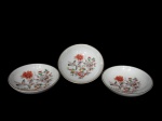 VISTA ALEGRE (Portugal, 1824), Três pequenos bowls confeccionados em porcelana portuguesa esmaltada na tonalidade branca, com pintura de flores, folhagens e pássaros em policromia e borda filetada a ouro, medindo 12cm de diâmetro.