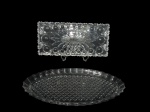 CRISTAL, Lote com 2 peças, sendo: A) 1 travessa para rocambole confeccionada em cristal translucido com lapidação repuxada, esferas e sulcos em baixo relevo, medindo 31x14cm e B) 1 travessa oval confeccionada em cristal translucido lapidado por losangos, medindo 37x20cm.