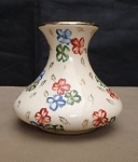 Pequeno vaso de porcelana de procedência europeia numerado na base, decoração de flores filetado a ouro na borda. configuração bojuda. Alt. 9,5cm