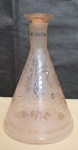 Diferente garrafa no formato Erlenmeyer em vidro no tom rosê decorado co flores e folhas. alt. 17cm.