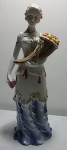 Linda estatueta em porcelana chinesa em perfeito estado, dama ricamente policromada segurando uma cornucópula com frutas, vestido filetado a ouro. Alt. 30cm.