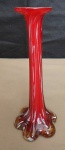 Solifleur em vidro de murano na cor vermelha sobre fundo branco no formato cilíndrico, borda revirada e base gomada com rajadas na cor branca. med:18cm