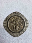 ARTE SACRA, uma (1) antiga medalha para fixação em berço de criança, representando anjo da guarda, confeccionada em metal prateado, medindo aproximadamente 60 mm diâmetro, sinais de uso e mossas, possui furo, vide foto.RUA MONSENHOR JERÔNIMO-ENGENHO DE DENTRO