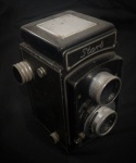 Câmera START B fabricada na Polônia entre 1960 e 1967. Tem a lente EUKTAR.  A"Start B" foi um sucesso e era oferecida com o nome de "Noco flex" no mercado americano e "Universa Uniflex 66" no mercado alemão. Alt: 14cm Larg:11cm Prof: 10cm
