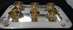 Bandeja de Prata Alessi com seis copinhos em bronze. Possui detalhes que se assemelham a parafusos em sua borda. Bandeja medindo Comp: 26cm Larg: 37cm
