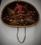 Lindo Sombrero decorativo em tecido aveludado vermelho com decorações em dourado representando ramos e folhas. Diâmetro: 16cm