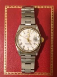 Relógio Rolex Oyster Perpetual Date, referência 1505,  pulseira oyster refêrencia 78350, aro e coroa em ouro 18k, mostrador branco com algarismos romanos, acompanha estojo, certificado e documentos.