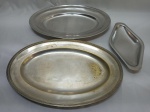 Lote de travessa e petisqueira em aço inox e uma travessa oval em prata 90. Medindo a maior 37,5cm x 25cm.