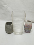 Lote de 3 vasos floreiras, sendo um em vidro, um em porcelana e um em pedra. Medindo o vaso 10cm x 10cm x 20,5cm de altura.