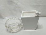 Lote composto de 2 cachepots, sendo um em porcelana e um em vidro. Medindo o cachepot em porcelana 14cm x 14cm x 34cm de altura. Leve bicado.