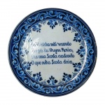 Prato medalhão em porcelana portuguesa ricamente adornado e com poema à Virgem Maria. Assinado no verso. Medidas: 31 cm de diâmetro.