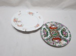 Lote de 2 pratos decorativos em porcelana, sendo um floral e um oriental. Medindo o maior 25cm de diâmetro, com pequeno bicado.