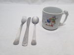 Kit infantil composto de caneca em porcelana, garfo, faca e colher em aço inox.  Medindo a caneca 7cm x 6,5cm de altura.