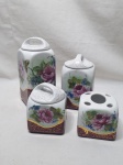 Toucador com 4 peças em porcelana, pintura floral e friso ouro. Medindo o maior 18,5cm de altura. Um deles com restauro na borda.