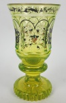 FABULOSO GOBLET BIEDERMEIER PRODUÇÃO DA BOHEMIA POR VOLTA DE 1830. ESSE ESPETACULAR GOBLET COM RICO TRABALHO EM ESMALTES, ARREMATES EM OUJRO E MAGNIFICO FEITIO É CONSTRUÍDO EM VIDRO IMPREGNADO COM URALINA, UM MINÉRIO RICO EM URÂNIO. EM TUDO É ENCANTADOR! PEÇA DE MUSEU! BOHEMIA, DEC. 1830. 16,5 X 9 CM (possui um bicado pouco perceptível na borda)NOTA: O vidro de urânio é vidro que contém urânio, geralmente em forma de óxido diuranato, adicionado a uma mistura de vidro antes da fusão. A proporção, geralmente, varia de níveis para cerca de 2% em peso de urânio, apesar de que no século XIX, peças foram feitas com até 25% de urânio.O vidro de urânio era feito, algumas vezes, em mesas e artigos domésticos, mas caiu fora de uso generalizado quando a disponibilidade de urânio para a maioria das indústrias foi severamente usada durante a Guerra Fria. A maior parte desses objetos são agora considerados antiguidades ou colecionáveis, embora tenha havido uma menor evolução na arte do vidro. Caso contrário, o moderno vidro de urânio está agora limitada principalmente a pequenos objetos como esferas ou mármores como novidades científicas ou decorativa. Devido a fraca radioatividade do urânio e além de sua pequena quantidade misturada ao vidro não é considerado um material de risco no uso humano.