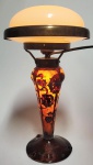 LE VERRE FRANÇAIS  SCHINEIDER - MAGNIFICA LAMPADA CHARDER EM CAMEO GLASS MODELO MARRONS (CASTANHAS) CRIADO POR CHARLES SCHINEIDER ENTRE 1922 E 1925. PADRÃO ESTILIZADO DE CASTANHAS SOBRE UM FUNDO DE JASPE AMARELO E LARANJA. ASSINATURA NO PÉ LE VERRE FRANÇAIS. ESATE MODELO ESTÁ LISTQADO NA PAGINA 111 EM CHARLES SCHINEIDER  LE VERRY FRANÇAIS CHARDER POR MARIE-CHRISTINE JOULIN E GEROLD MAIER, 2020.  ELETRIFICADO TAMBÉM INTERNAMENTE. FIAÇÃO ANTIGA ORIGINAL.  EXCELENTE ESTADO DE CONSERVAÇÃO! FRANÇA, DEC. 1930. 39 CM DE ALTURA. NOTA: CHARDER era um nome composto pela primeira parte de Charles e a segunda parte de Schnieder. Às vezes, era marcado em vidros projetados por Charles Schneider, particularmente peças da linha Le Verre Francais. Le Verre Francais era uma linha especial de designs de vidro artístico feitos pela Schneider Glassworks na França entre 1918 e 1939. O nome era usado pelos Schneiders para vasos de vidro camafeu de 2 ou 3 camadas, tigelas, jarras, lâmpadas etc. em um estilo que combinava características art déco e art nouveau. Esta linha foi introduzida pela primeira vez em 1918 e era vendida em sua própria galeria de varejo em Paris, administrada por sua irmã Ernestine. O vidro Le Verre Francais também era vendido em grandes lojas de departamento em Paris e nos EUA e Europa. Charles e Ernest Schneider eram uma geração mais jovens que Emile Galle e os irmãos Daum, cujas vidrarias ficavam na mesma área da França. Os irmãos Schneider trabalharam para a Daum desde o início dos anos 1900, Ernest como vendedor/gerente comercial e Charles como designer freelancer. Os irmãos deixaram a Daum por volta de 1912 e recomissionaram uma antiga vidraria sob o nome Schneider Freres et Wolff (Irmãos Schneider e Wolff), algumas milhas ao norte de Paris em 1913. Henri Wolff era um arquiteto amigo de Charles Schneider. Inicialmente, eles faziam vasos e lâmpadas de camafeu de alta qualidade, mas a guerra na Europa (1914-1918) levou Charles e Ernest e a maioria de seus qualificados vidreiros para lutar na guerra. Eles retornaram e reabriram suas vidrarias em 1917 para fazer artigos de vidro necessários para hospitais e, após a guerra, venderam ações da empresa para financiar o retorno ao mercado de vidro artístico. Naquela época, a empresa era chamada de Societe Anonyme des Verreries Schneider. Charles Schneider era um designer brilhante e versátil, e a empresa produziu uma ampla gama de designs excelentes. Eles foram muito bem-sucedidos em comercializar seus vidros para grandes lojas de varejo de alto prestígio, tanto em Paris quanto no exterior. Eles compraram de volta suas ações e renomearam a empresa Verrerie Schneider. Praticamente todas as suas peças são marcadas com o nome SCHNEIDER ou com uma de suas outras marcas registradas. Às vezes, a assinatura em uma peça Schneider era complementada ou substituída por um pequeno pedaço de cana de vidro vermelho, branco e azul colocado no vidro (um gesto patriótico). Se a palavra "França" aparecer como parte da assinatura Schneider, isso indica uma peça feita para exportação e provavelmente feita depois de 1945 na Cristallerie Schneider. A depressão na década de 1930 foi um grande revés para a Schneider's, porque seu mercado nos EUA entrou em colapso para eles. Seu bem-sucedido, mas longo processo judicial contra David Gueron (vidro DEGUE) também foi uma fonte de dificuldades para a empresa no início da década de 1930. E seu vidro soberbamente colorido saiu de moda na França. Em 1937, Ernest Schneider morreu, e em 1939 a empresa foi declarada falida e a vidraria foi vendida para uma empresa de sucos de frutas. No início da Segunda Guerra em 1940, o exército alemão invasor despejou o conteúdo da vidraria, destruiu muitos de seus registros e a transformou em uma cervejaria. Cristallerie Schneider foi uma nova vidraria criada por Charles Schneider e seus dois filhos, Charles e Robert, em 1949. Charles Schneider sênior morreu em 1953. A Cristallerie Schneider operou até 1957, quando a obra foi destruída por uma explosão, e durante esse tempo eles produziram algumas belas linhas em vidro soprado de cristal de chumbo, frequentemente com borbulhamento interno aleatório. Em 1957/58, Charles Schneider Jr. e seu irmão Robert Henri construíram outra nova vidraria, chamando-a de Verrerie Schneider. Eles fizeram Schneider Art Glass até 1981, quando ambos se aposentaram e fecharam a empresa.