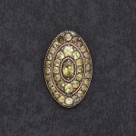 Antigo Broche em ouro e Crisólitas, forma oval, medindo 2 cm por 3 cm. Falta uma pedra.