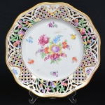 Prato em porcelana Alemã, marcado, pintura do flores e borda fenestrada, medindo 26,5 cm de diâmetro.