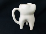 Caneca em faiança no formato de dente. Med. 15x12 cm.