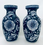 Par de vasos em porcelana, com decoração de flores e arabescos em tom azul, em perfeito estado. Med. 26x12 cm.