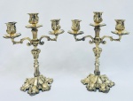 Par de candelabros para três velas em bronze, decorados com volutas e relevos. Med. 29x24 cm.