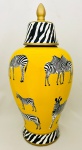 Grande potiche em porcelana na cor amarela, decorado por zebras e detalhes em dourado. Med. 49x24 cm.